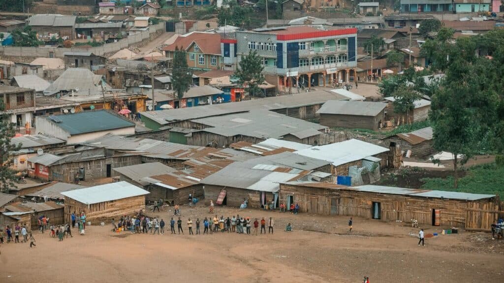 Aerial view of a lively community scene in an African town with colorful buildings.