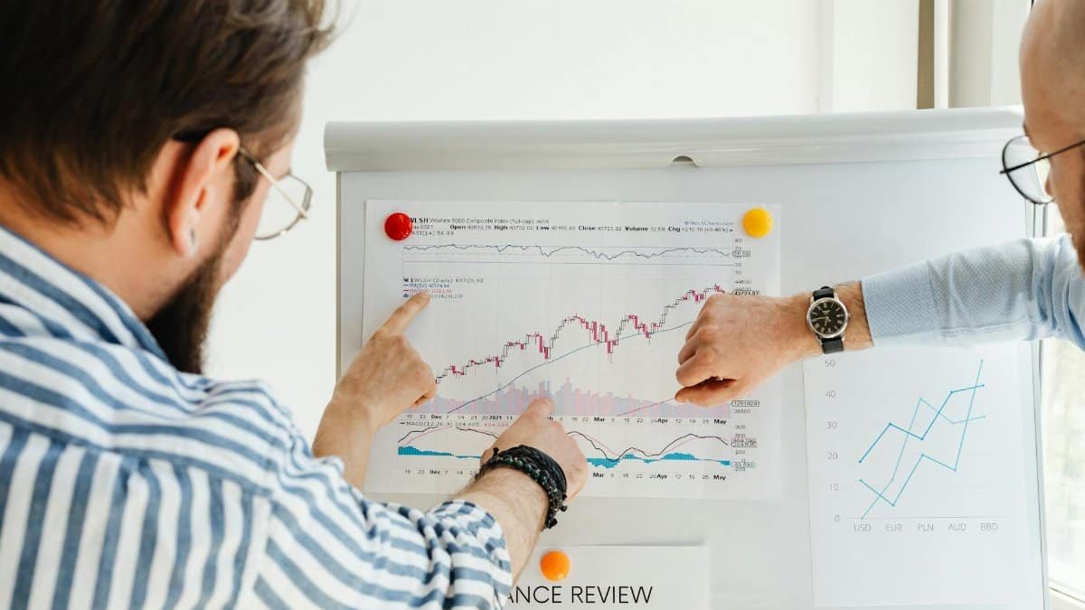 Colleagues discussing data trends on a whiteboard with graphs and charts.