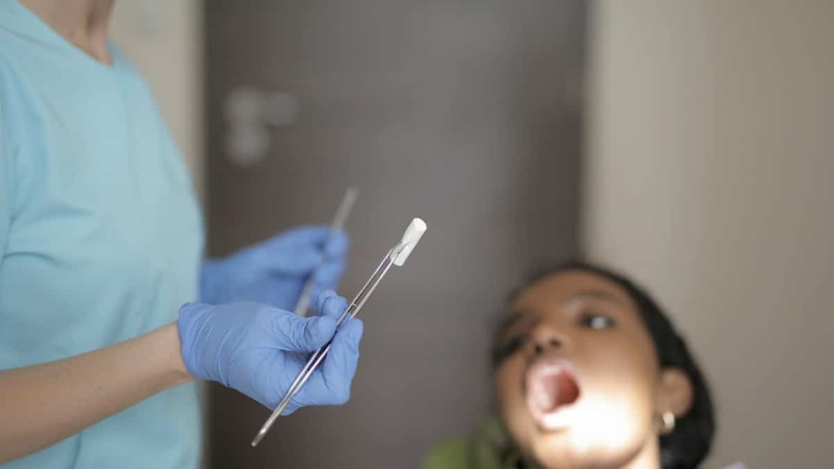 Dentist conducting oral examination on patient with dental instruments.