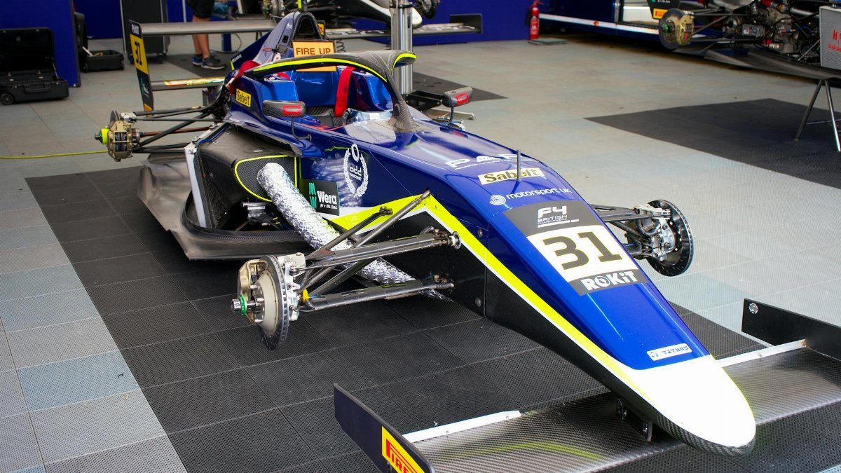 Detailed view of an F4 race car being prepped in a Silverstone garage.