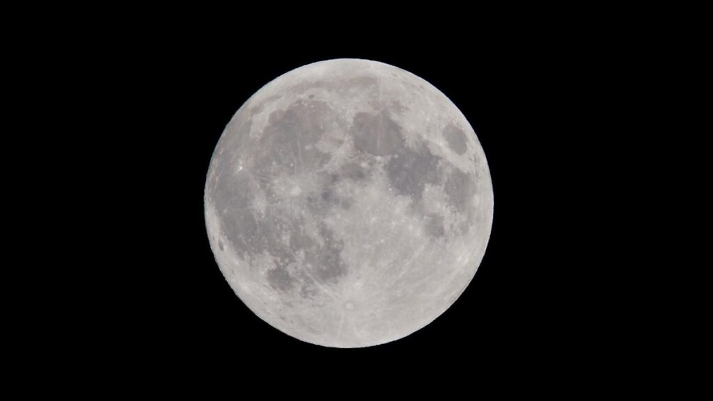 Stunning full moon against a dark night sky, showcasing captivating lunar details.
