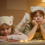 Cute children wearing animal-themed sleep masks, resting indoors during bedtime.
