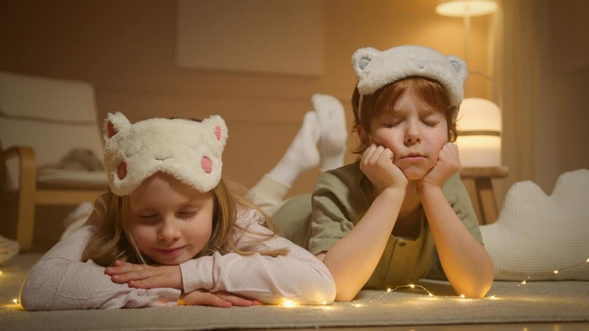 Cute children wearing animal-themed sleep masks, resting indoors during bedtime.