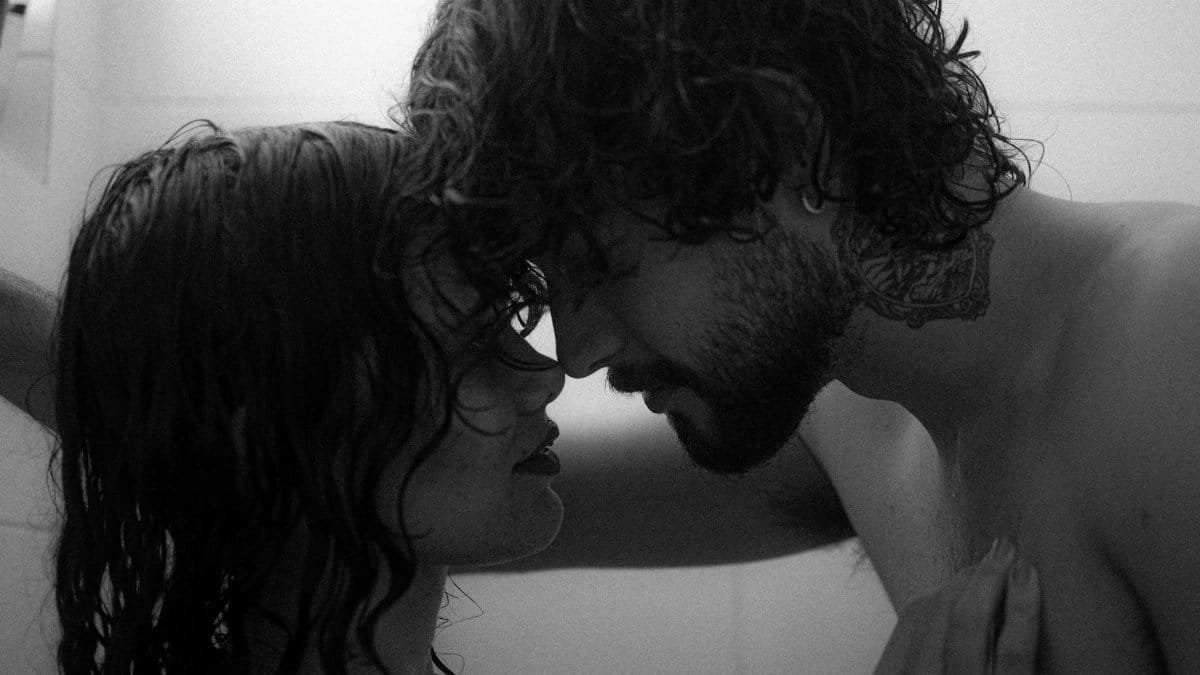 Romantic black and white photo of a young couple sharing an intimate moment in the shower.