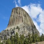 Stunning landscape of Devils Tower, Wyoming, USA with clear skies and rocky formations.