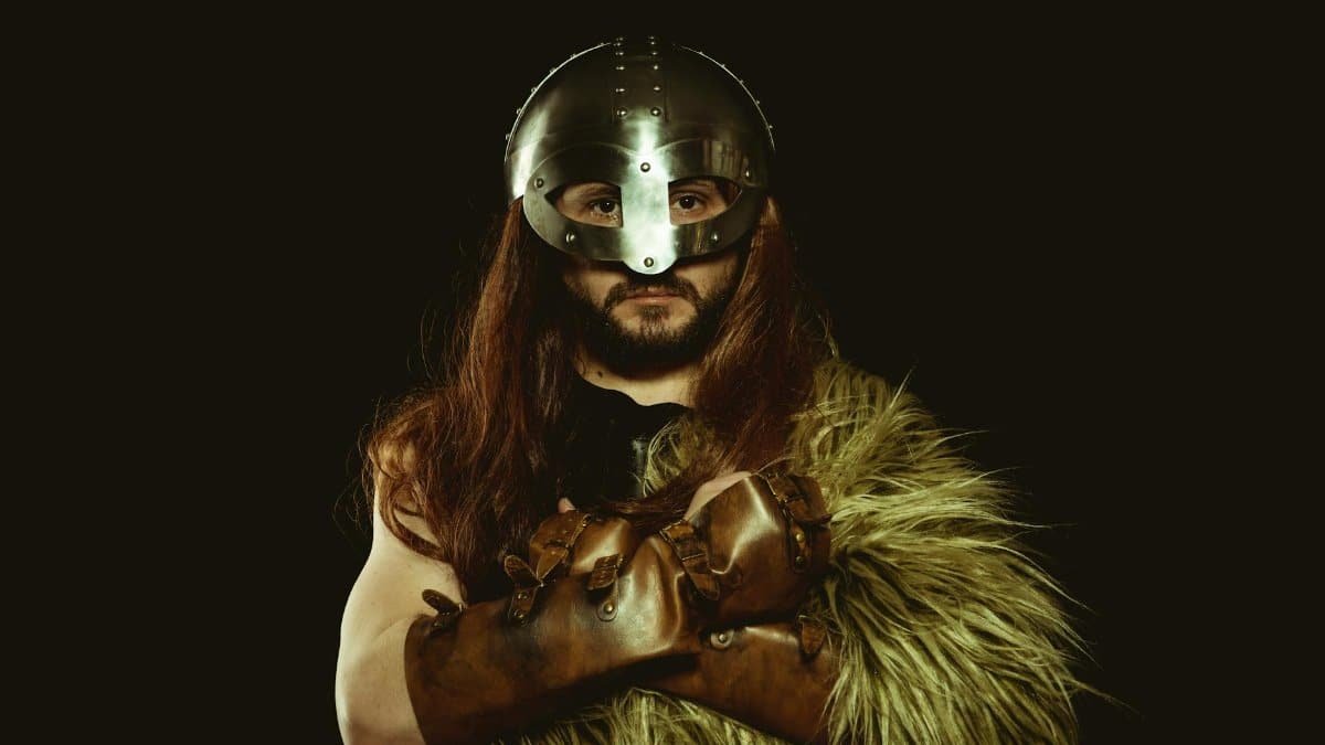 A viking warrior in armor, posing confidently with crossed arms and wearing a helmet.