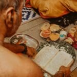 An intimate view of a traditional ceremony with ritual offerings and sacred texts.