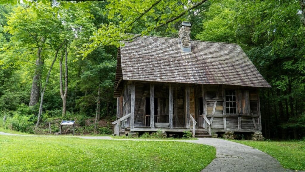 A rustic log cabin nestled in lush green woods, capturing Appalachian heritage.