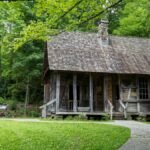 A rustic log cabin nestled in lush green woods, capturing Appalachian heritage.