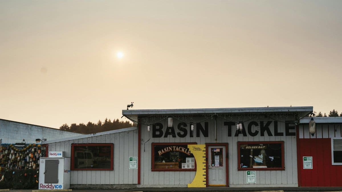 Sunlit facade of Basin Tackle shop, capturing rural charm in Bandon, Oregon.