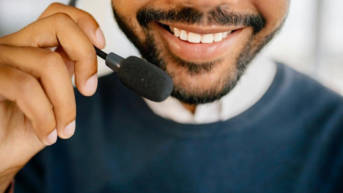 A cheerful call center agent wearing a headset and microphone, providing excellent customer service.