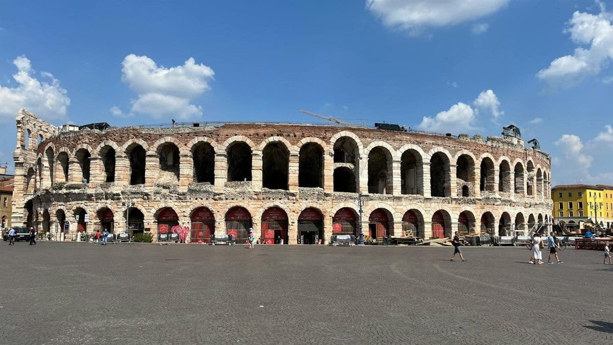 The ancient Verona Arena stands majestic under clear blue skies, a symbol of Italian history and architecture.