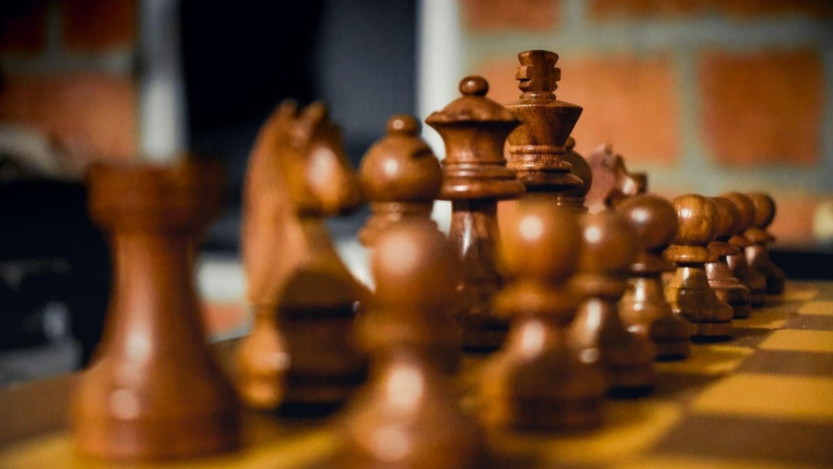 Detailed view of wooden chess pieces on a board, highlighting strategic gameplay setup.