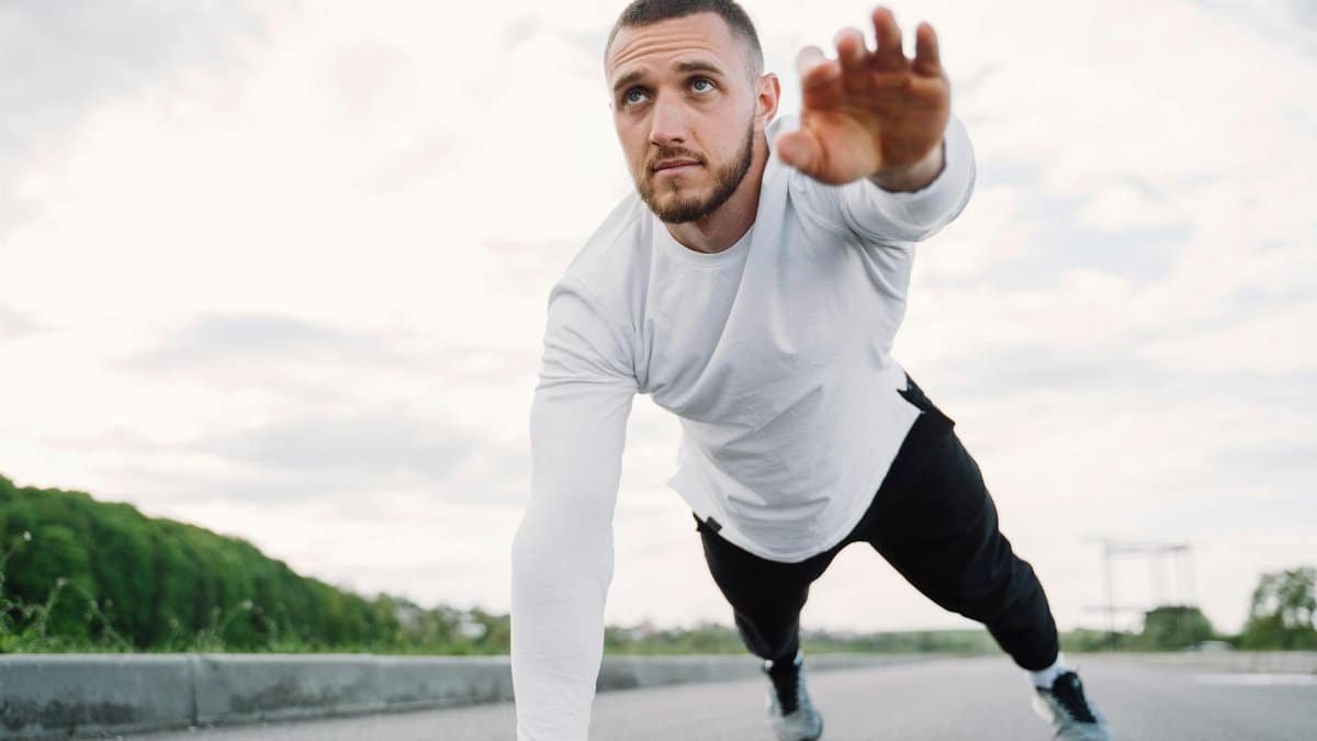 Adult male doing a core exercise on a rooftop in sportswear, promoting fitness and healthy living.
