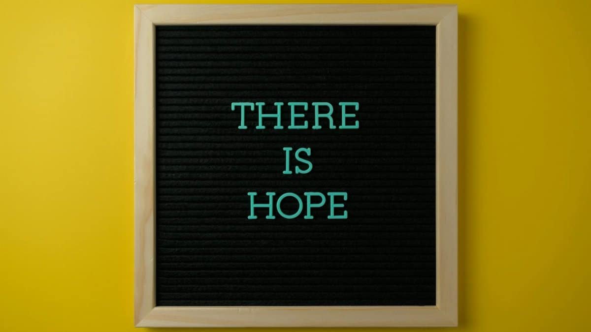 Letter board with 'THERE IS HOPE' message against a vibrant yellow backdrop.