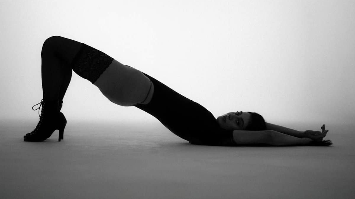 Artistic black and white photo of a woman posing gracefully indoors.