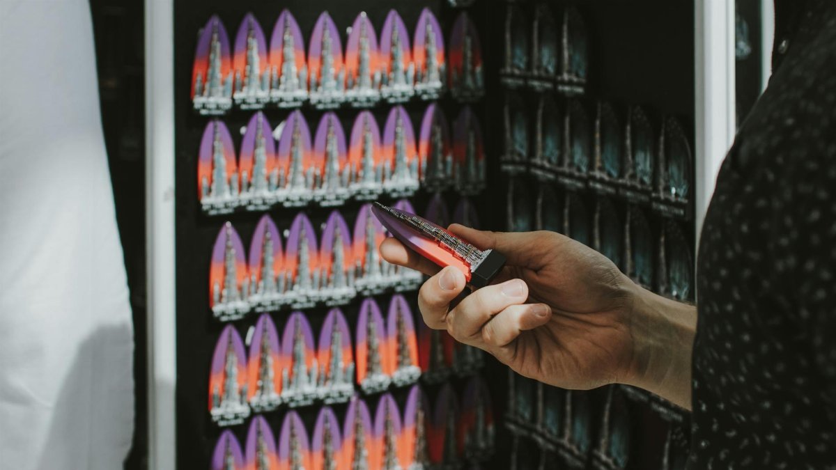 A hand holding a colorful magnet in a souvenir shop in Dubai, United Arab Emirates.