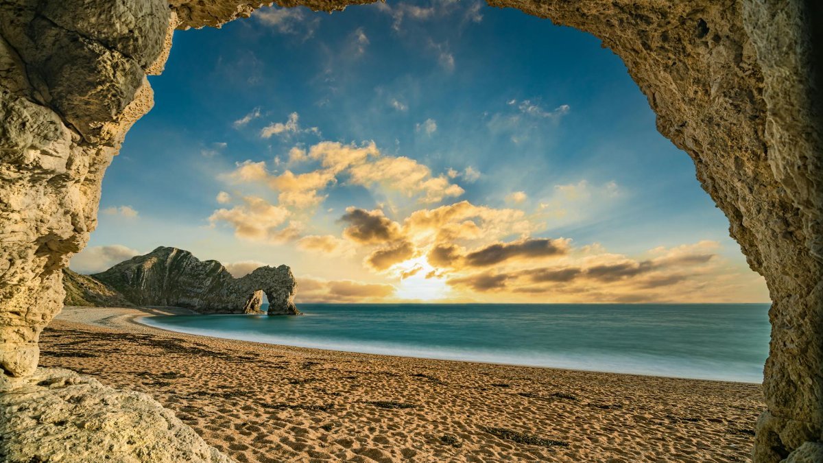 Stunning sunset at Durdle Door, showcasing the natural limestone arch on the Jurassic Coast in England.
