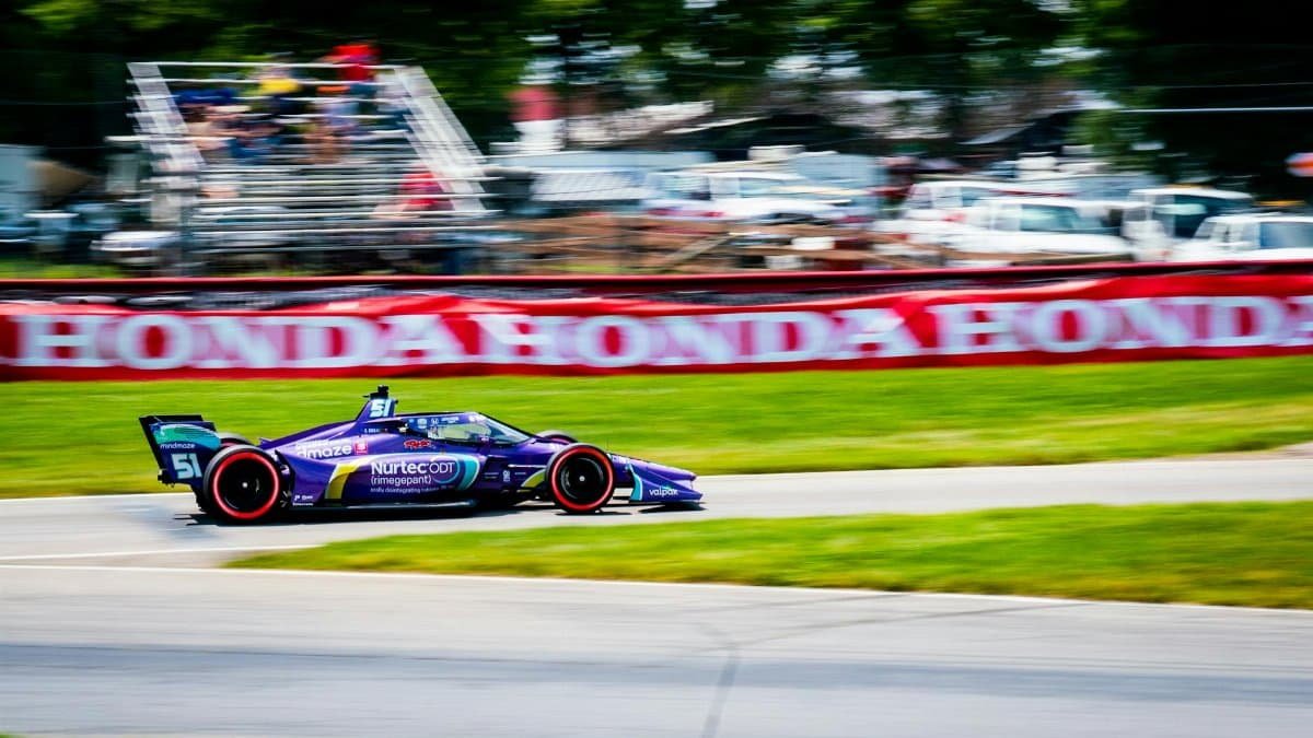 A thrilling IndyCar race car speeding through Mid-Ohio Sports Car Course in Lexington.