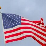 A vibrant image of the American flag waving proudly against a clear blue sky, symbolizing freedom.