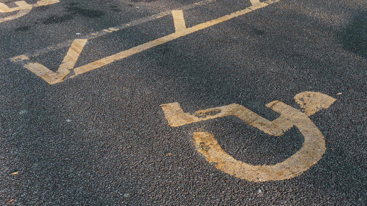 Prominent international wheelchair symbol on asphalt, illustrating accessibility.