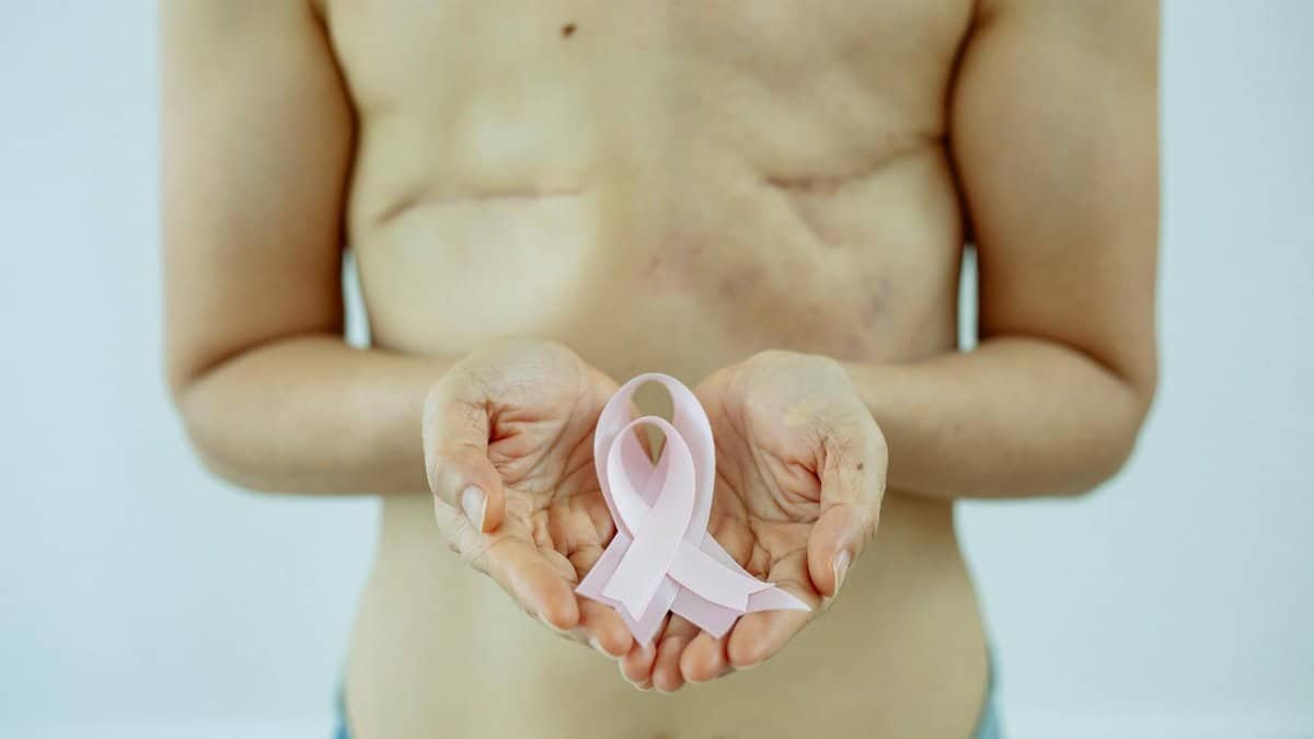 A breast cancer survivor displaying a pink ribbon symbolizing hope and strength.