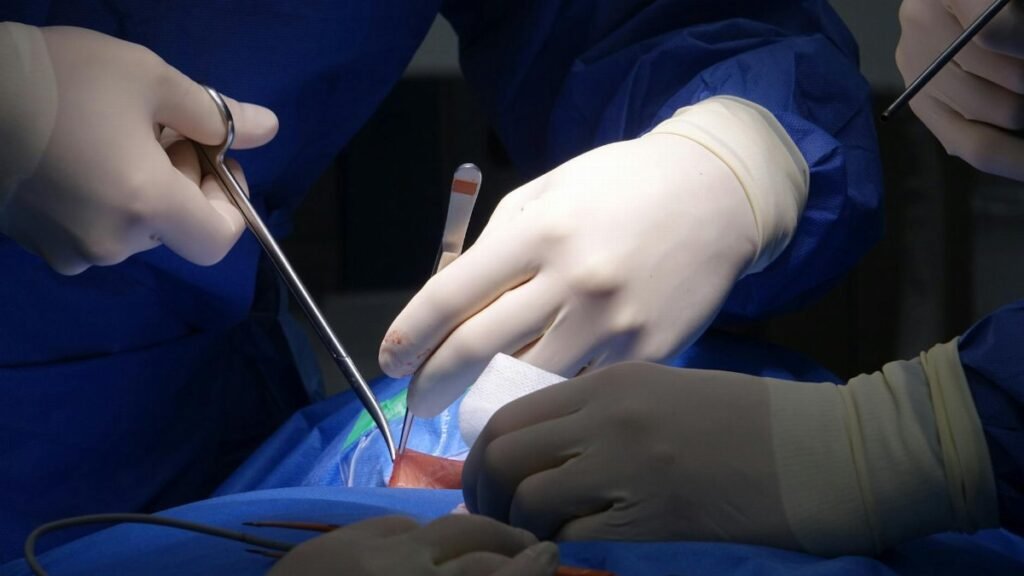 Detailed view of surgeons performing spinal surgery in a sterile operating room environment.