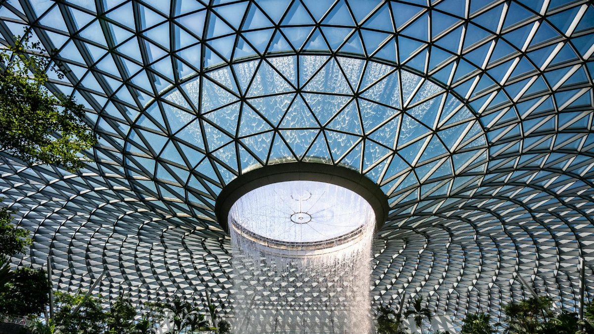 A stunning perspective of the Jewel Changi Airport's iconic indoor waterfall in Singapore.