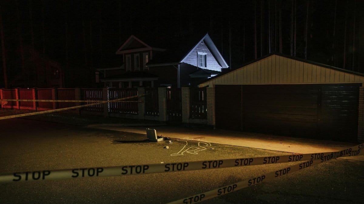 A night-time suburban crime scene with forensic evidence marked on pavement.