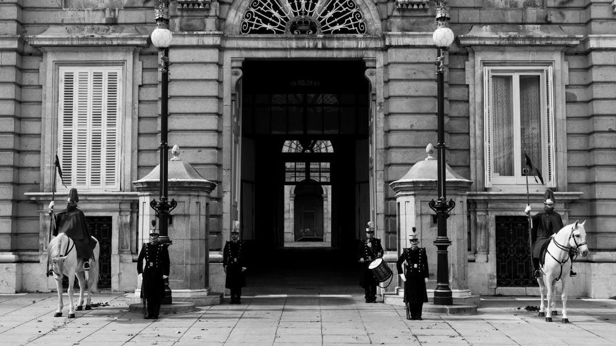 Black and white image of royal guards and horses at the Royal Palace of Madrid.