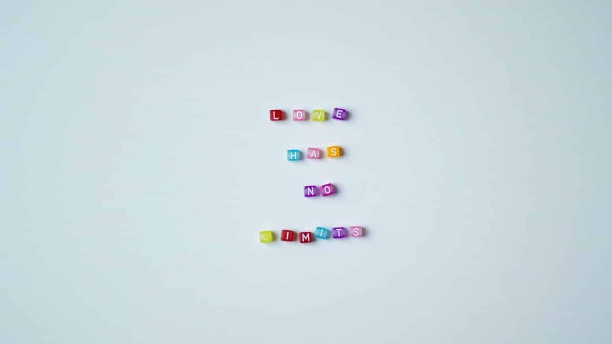 Vibrant bead letters spelling 'Love Has No Limits' on a gray background promoting inclusivity.