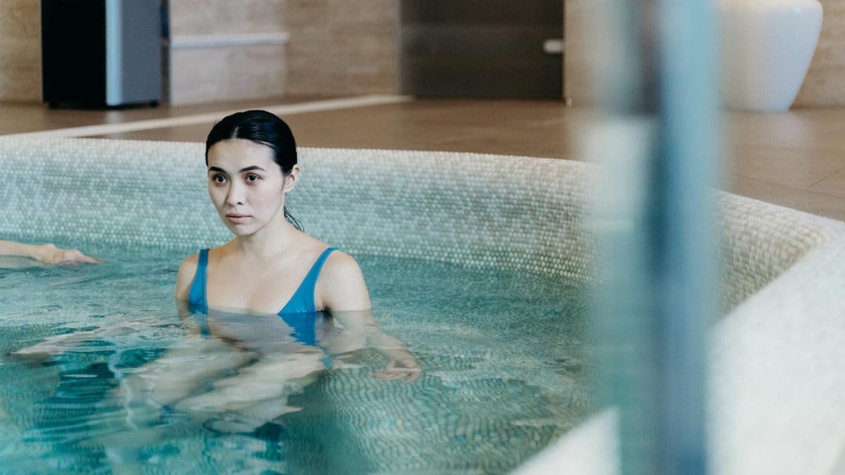 Calm woman enjoying leisure time in an indoor swimming pool. Perfect for lifestyle and wellness themes.