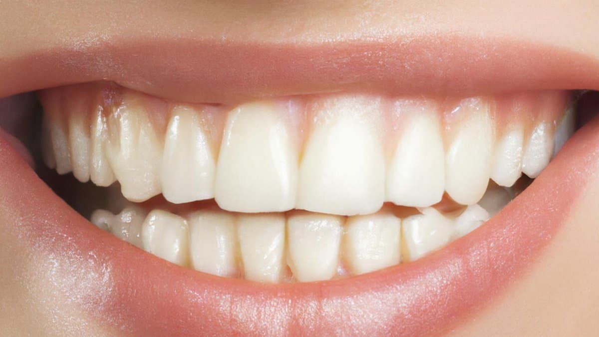 A detailed close-up of a perfect set of white teeth and lips in a bright smile.