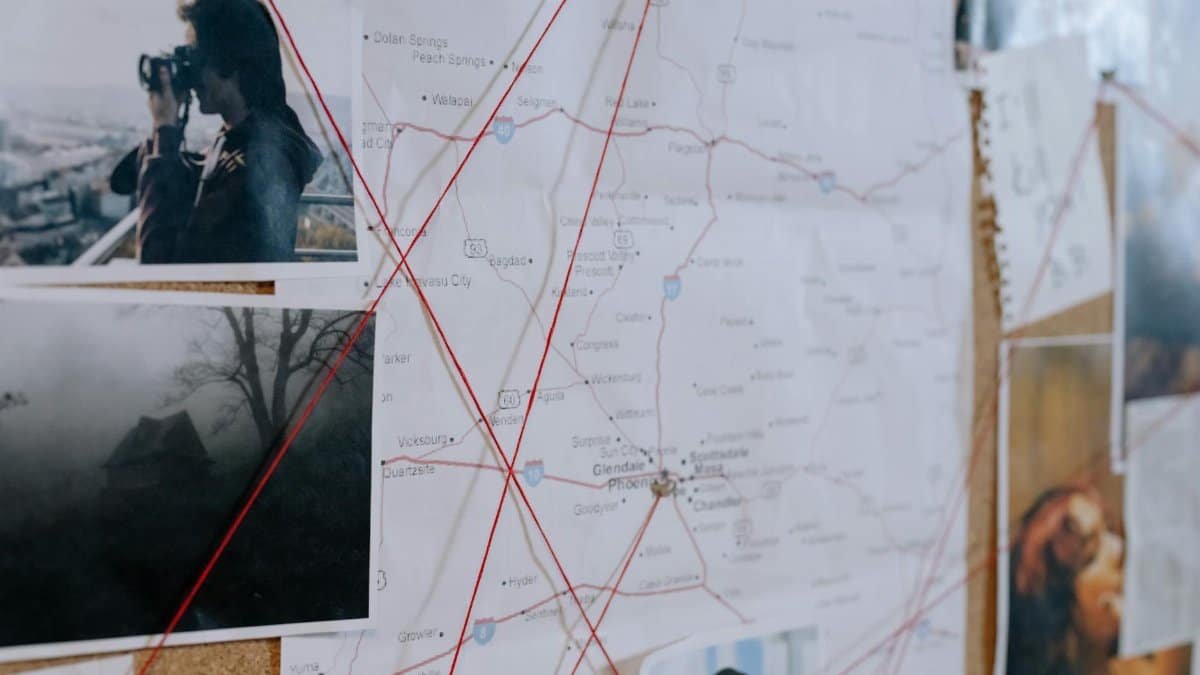 Investigative bulletin board with maps, photos, and red threads connecting clues.