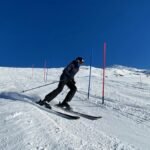 Skier skillfully navigating slalom course in snowy Les Belleville on a bright winter day.