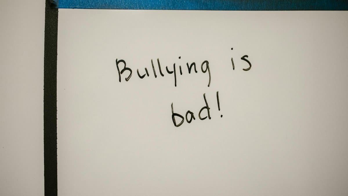 A handwritten message on a whiteboard promoting anti-bullying awareness and prevention.
