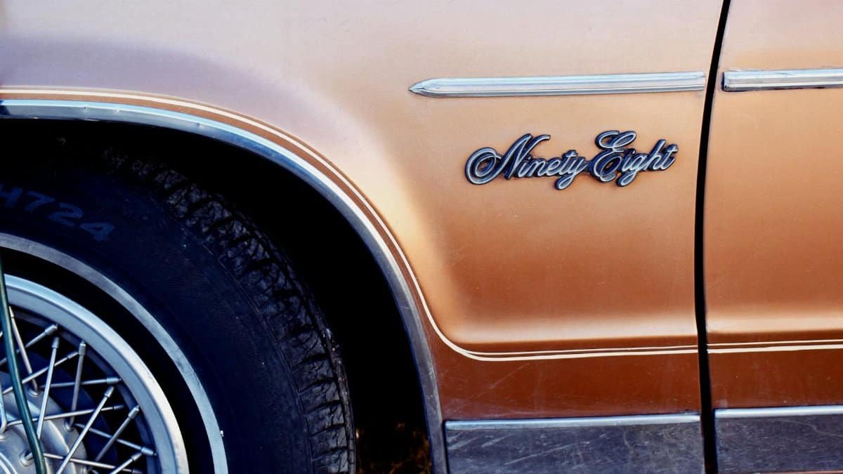 Close-up of an orange Oldsmobile Ninety-Eight showing vintage design details.