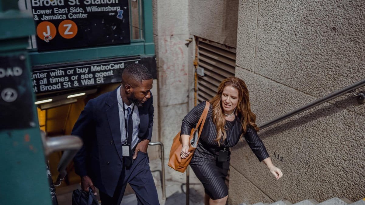 Two business professionals in suits walking up stairs at Broad Street Station.