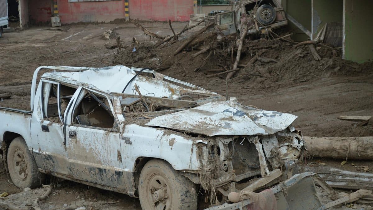 Crushed vehicle amid debris following a severe mudslide in Mocoa, Colombia, highlighting destruction.