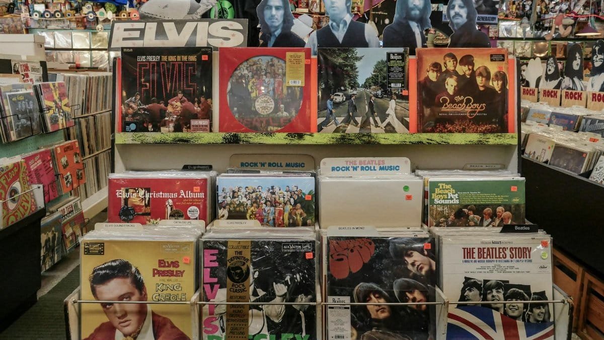 Retro vinyl collection featuring The Beatles and Elvis Presley in a classic music shop.