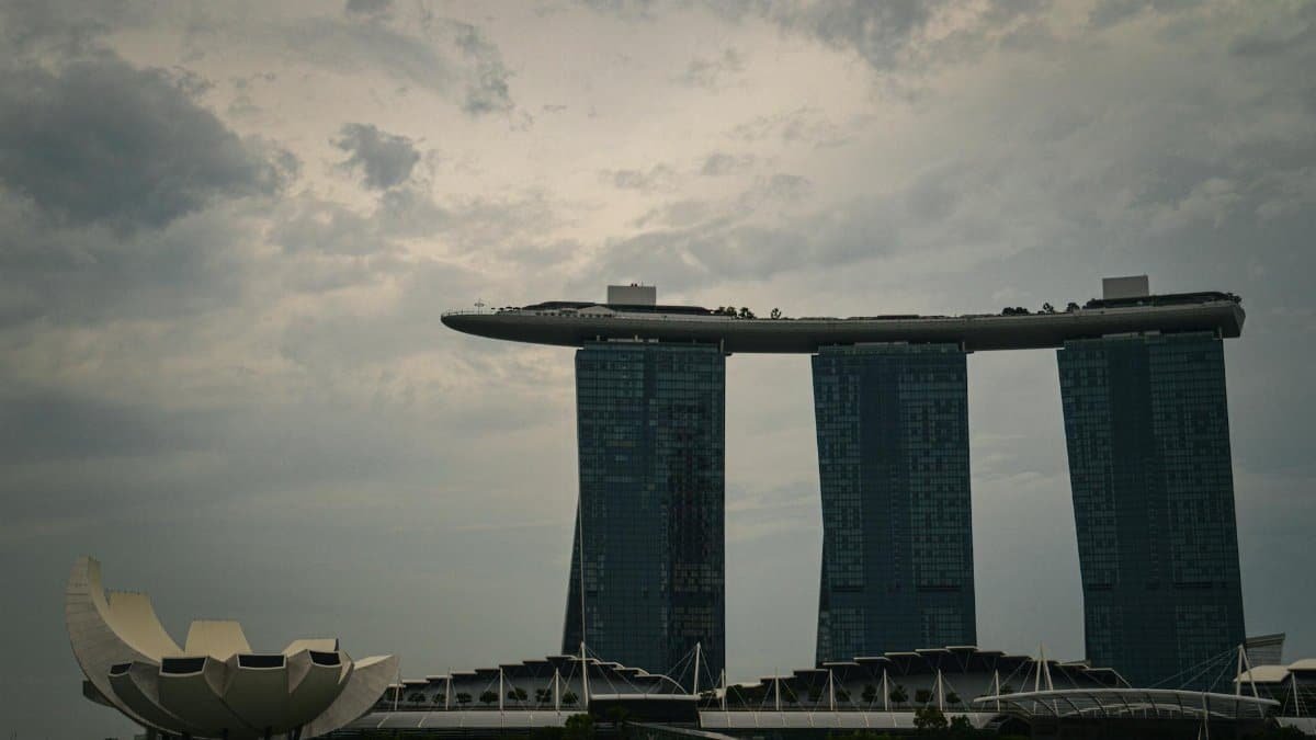Dramatic view of Marina Bay Sands and ArtScience Museum under cloudy skies in Singapore.