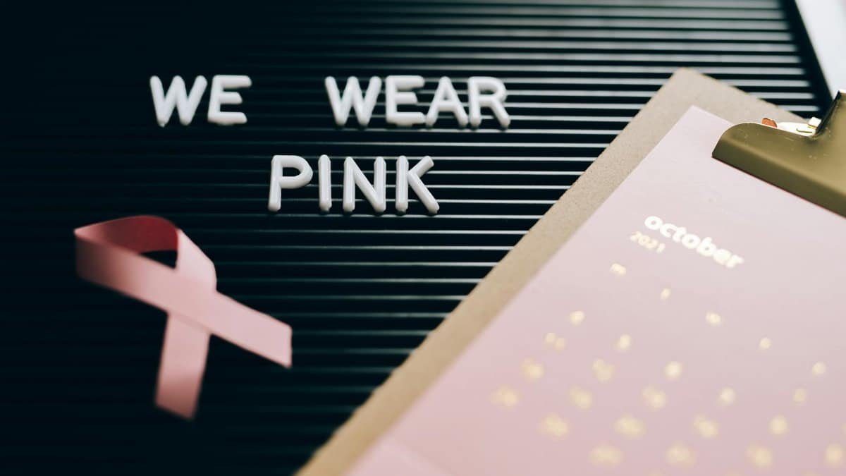 Pink ribbon, calendar, and board with 'We Wear Pink' for breast cancer awareness.