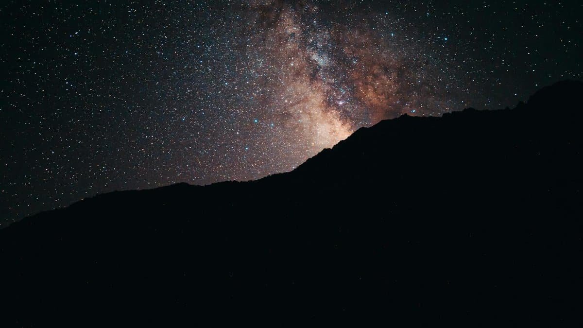 Beautiful view of the Milky Way galaxy over a mountain silhouette under a starry night sky.