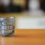 A close-up of a glass cup with 'All You Need is Love' text, ideal for lifestyle themes.