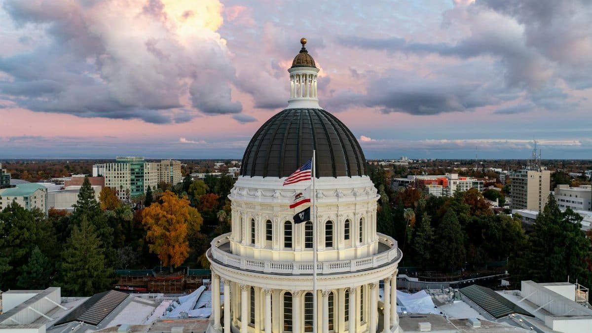 A stunning aerial view of the California State Capitol Dome under a colorful sky at dusk.