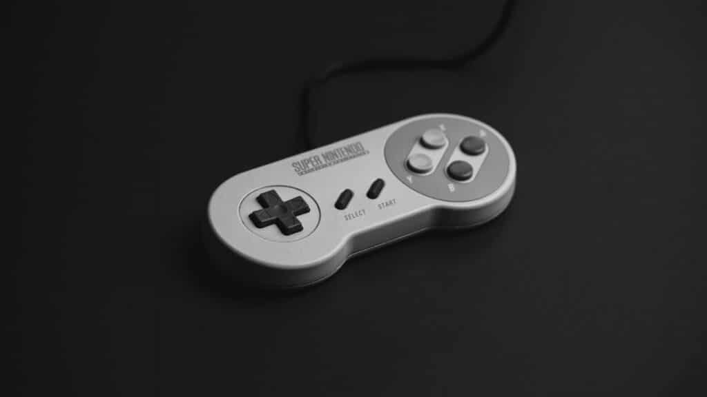 Close-up of a vintage Super Nintendo controller on a black background.