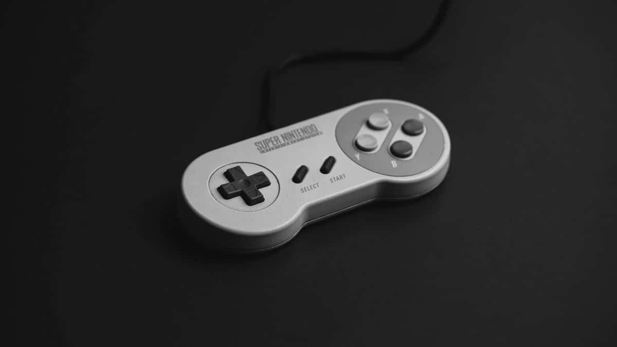 Close-up of a vintage Super Nintendo controller on a black background.