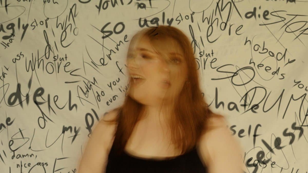Motion blur effect of a woman with graffiti showcasing emotional distress in the background.