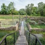 A child explores ancient ruins at Dion, Greece on a sunny day, highlighting history and adventure.