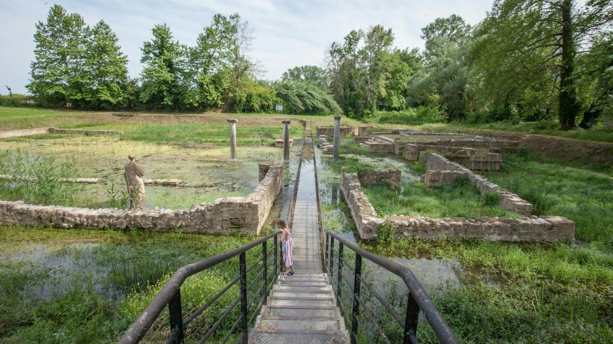 A child explores ancient ruins at Dion, Greece on a sunny day, highlighting history and adventure.